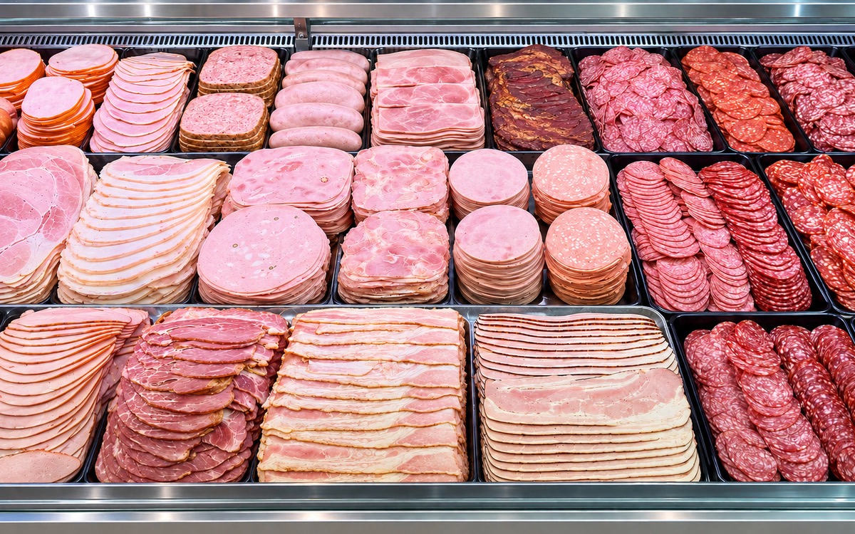 Krájené šunky, salámy a slanina v přehledných řadách